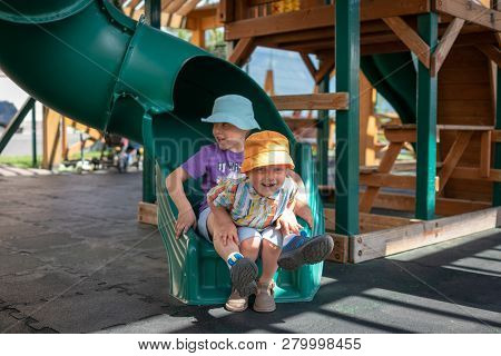 Two Boys Slid Down The Slide On The Playground