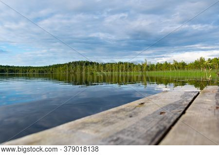Beautiful Lake And Pine Tree Forest With Reflections In Latgale, Latvia, Europe With Wooden Pier
