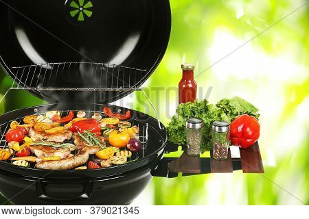 Barbecue Grill With Meat Products And Vegetables On Blurred Green Background, Closeup