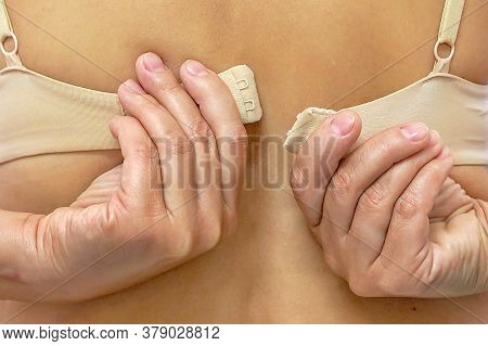 Closeup Of Woman Hands Unfastening Bra. Lower Lingerie. Female Hands Unfasten The Bra. Back View