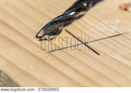 A Closeup Portrait Of A Wood Drilling Bit Lying On A Wooden Plank Next To A Pencil Marking Where The