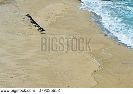 A Row Of Eleven Sunshades On The Beach In Odeceixe On The Atlantic Coast Of Portugal