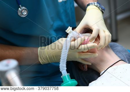 The Child Is Under Anesthesia. Withdrawal From Anesthesia. The Anesthesiologist Holds A Breathing Ma