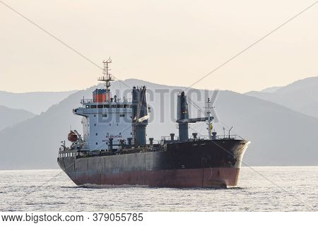 An Old Bulk Carrier Or Bulker Sails In The Sea Near Shore.