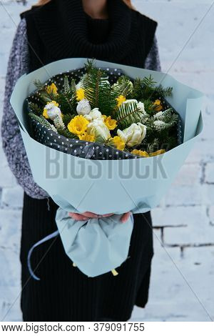 Bouquet Of Flowers And Fir Branches In Blue Package In The Hands Of Woman Florist In Knitted Sweater