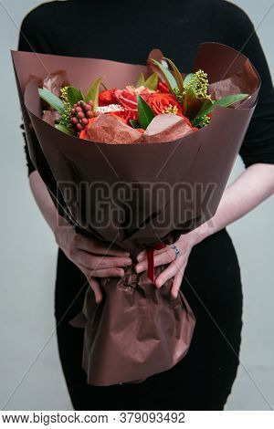 Bouquet Of Flowers In Burgundy Package In The Hands Of A Woman Florist On Light Background. Rosa, Sk