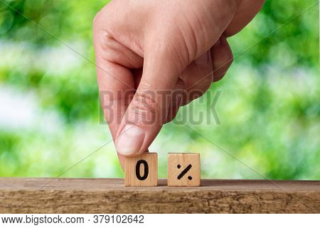 Male Hand Lays Out Wooden Cubes With Numbers On A Green Background. Zero Percent. Overpayment Loan