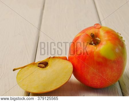 An Apple, On A White Wooden Background. Close-up. Dietary Nutrition.