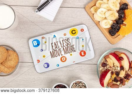 Healthy Tablet Pc compostion with EAT LESS MOVE MORE inscription, weight loss concept
