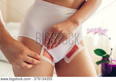 Waxing Bikini Area At Home. Young Sexy Woman Wearing Underwear And Holding Strips With Wax. Beauty C
