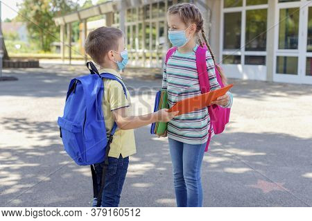 Back To School. Brother And Sister Or Boy And Girl Wearing Protective Medical Masks In The Schoolyar