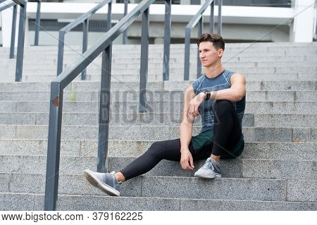 Portrait Of A Confident Sporty Man. Young Sportsman Sitting Outdoors After Good Jogging Workout. You