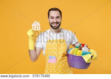 Smiling Young Man Househusband In Apron Rubber Gloves Hold Basin With Detergent Bottles Washing Clea