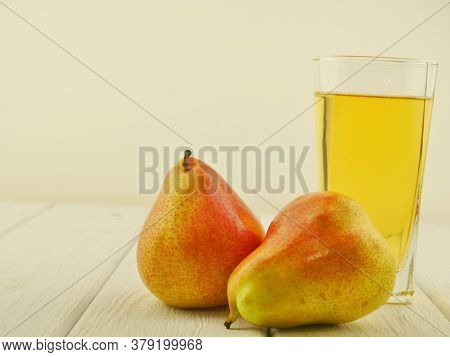 Two Ripe Pears And Pear Juice In A Glass On White Boards. Close-up. Proper Nutrition. Space For Text