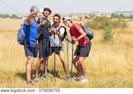Young People With Trekking Poles Doing The Camino De Santiago In Spain Taking A Selfie Photograph Wh