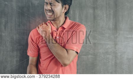 Young Asian Man Suffering From Neck Pain On Cement Wall Background With Copy Space, Problems And Hea