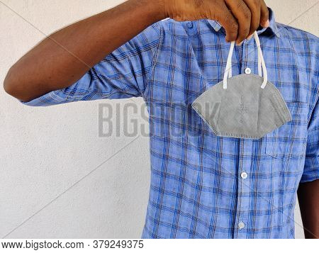 Young Man Holding One Grey Color Kn-95 Face Mask In His Hand. Blue Shirt Guy. Corona Virus Pandemic.
