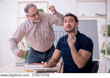 Old teacher and young male student in the classroom