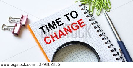 Notepad With Text Time To Change On White Background With Clips, Pen And Magnifying Glass