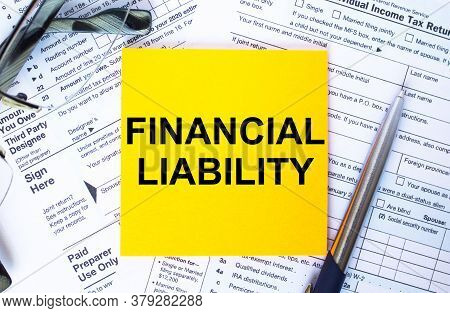 Text Financial Liability On Note Paper With The U.s Irs 1040 Form,pen And Glasses