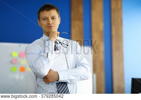 Portrait Of Businessman Posing On Camera Holding Clipboard. Smart Attractive Guy In Presentable Suit