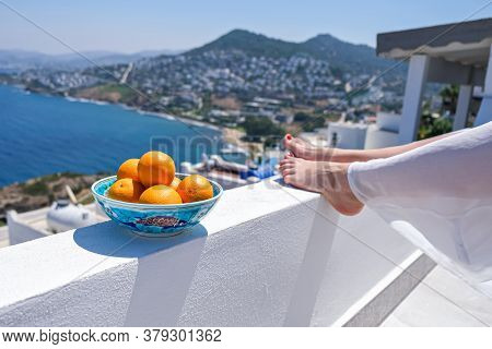 Woman Legs And Oranges On Terrace Bacony Of House Or Hotel Sea View