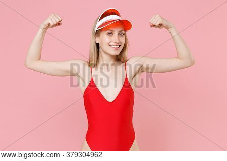 Smiling Strong Young Blonde Woman Girl In Red One-piece Swimsuit Cap Posing Isolated On Pink Backgro