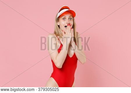 Shocked Young Blonde Woman Girl In Red One-piece Swimsuit Cap Posing Isolated On Pastel Pink Backgro