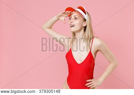 Young Blonde Woman Girl In Red One-piece Swimsuit Cap Isolated On Pink Background. People Summer Vac