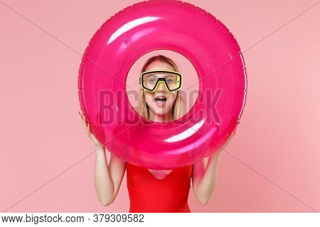 Amazed Young Woman Girl In Red One-piece Swimsuit Cap Swimming Goggles Posing Isolated On Pink Backg