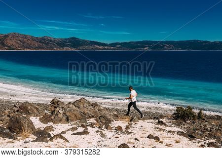 A Man Walks Along The Shore Of Lake Salda In Turkey. A Man Runs Along The Shore. A Man Runs Along Th
