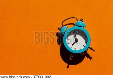 Blue Alarm Clock On Orange Background. Back To School Concept. Creative Design, Minimal Concept. Wak
