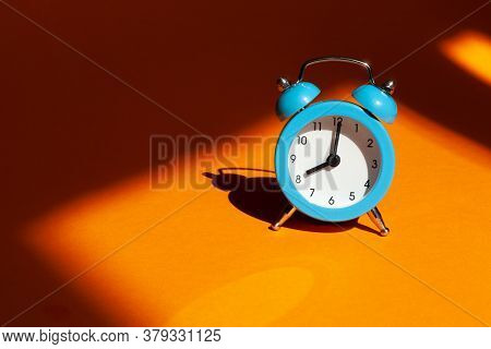 Blue Alarm Clock On Orange Background. Back To School Concept. Creative Design, Minimal Concept. Wak