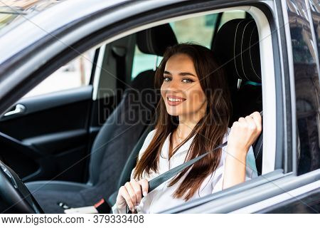 Safety First. Beautiful Young Woman Fastening Car Seat Belt Before Drive.