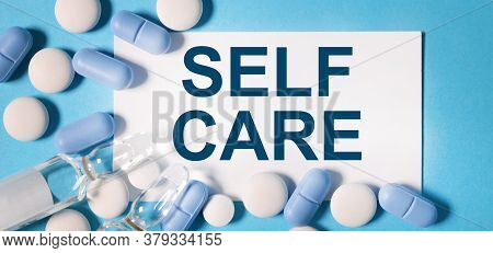 Self Care. Text On White Paper On A Blue Background Near Blue And White Tablets And A Transparent Am