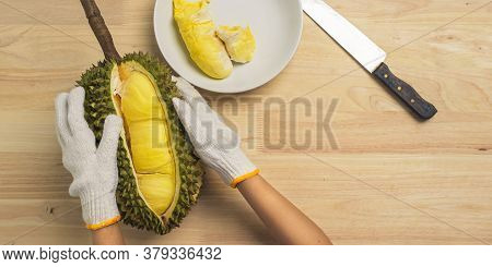 Top View Closeup Durian Peeling On The Table Wooden With Durian In Dish. Hand Of Person Wearing Glov