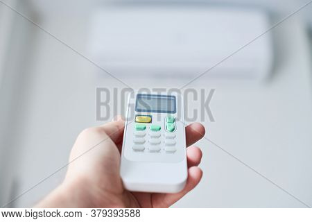 Air Condition Remote Control. Hand With Room Conditioner Remote Control. Air Temperature Switch For 