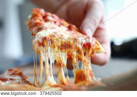 Male Arm Taking Slice Of Cheesy Tasty Fresh Pizza Close-up