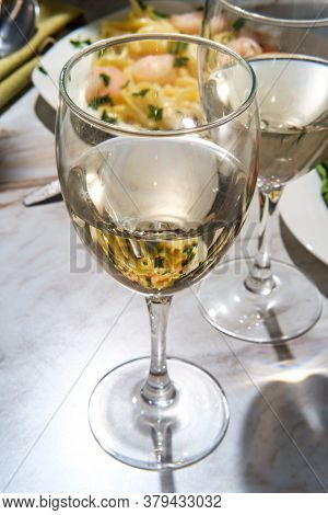 Romantic Italian Dinner With Two Glasses Of Pinot Grigio White Wine And Fettuccine Alfredo Shrimp In