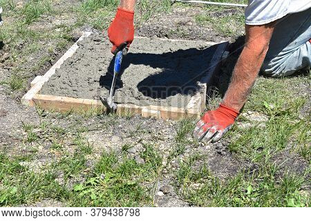 A Wood Square Form Surrounds S Hole Isfilled With Concrete  Which Will Serve As A Base For A Statue.