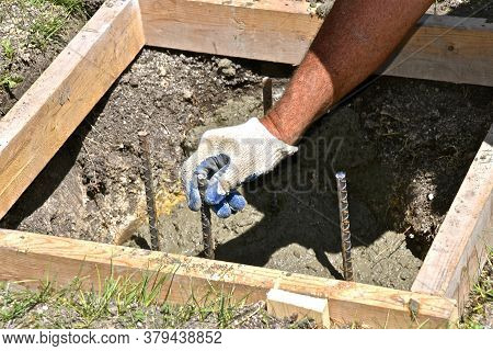 A Wood Square Form Surrounds A Hole Filled With Concrete And Anchor Rods Which Will Serve As A Base 