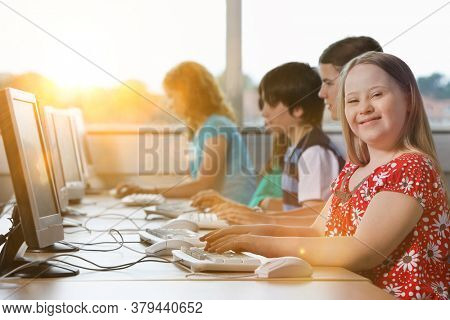 Girl with Down syndrome using computer at school