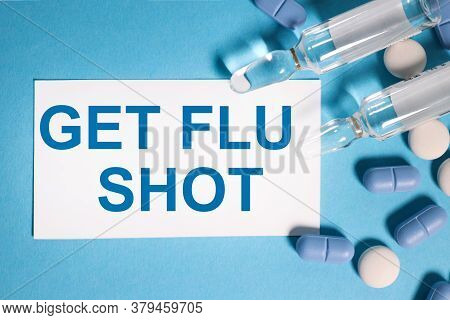 Get Flu Shot. Text On White Paper On A Blue Background Near Blue And White Pills And A Transparent A