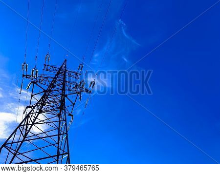 High Voltage Post Or Power Transmission Tower Agains Blue Sky. Silhouette Of Electricity Post And Hi
