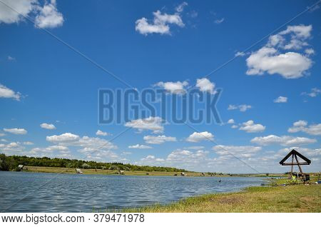 A Pond For Fishing And Recreation With Family And Children On A Sunny Day