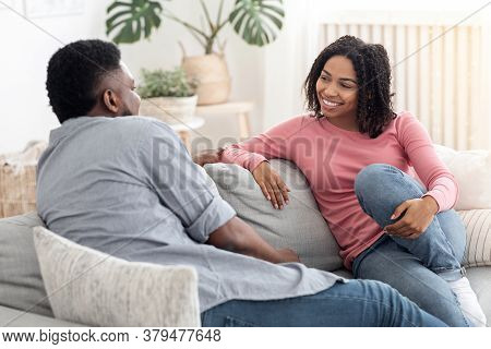 Communnication In Relationships. Loving Black Couple Chatting Together On Couch At Home, Enjoying We