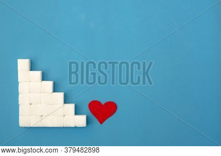 Laid Out A Ladder Of Sugar Cubes, A Red Heart At The Bottom Of The Stairs On A Blue Background, Copy