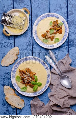 Traditional Polenta With Mushrooms And Cheese In A Dish On A Blue Wooden Background. Selective Focus
