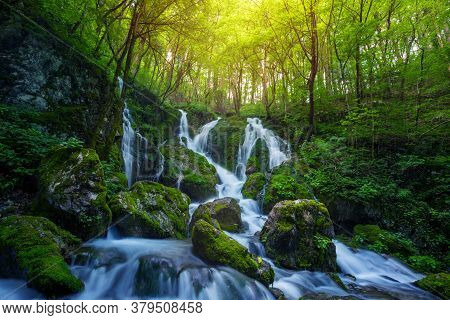 Beautiful Waterfall Cascade In Lush Green Forest.