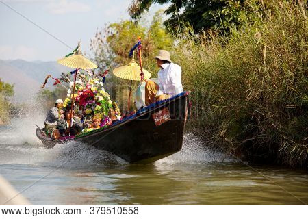INLE LAKE, MYANMAR - CIRCA FEBRUARY 2018: Widding boat with traditionaly dressed people on the Inle Lake in Myanmar.
